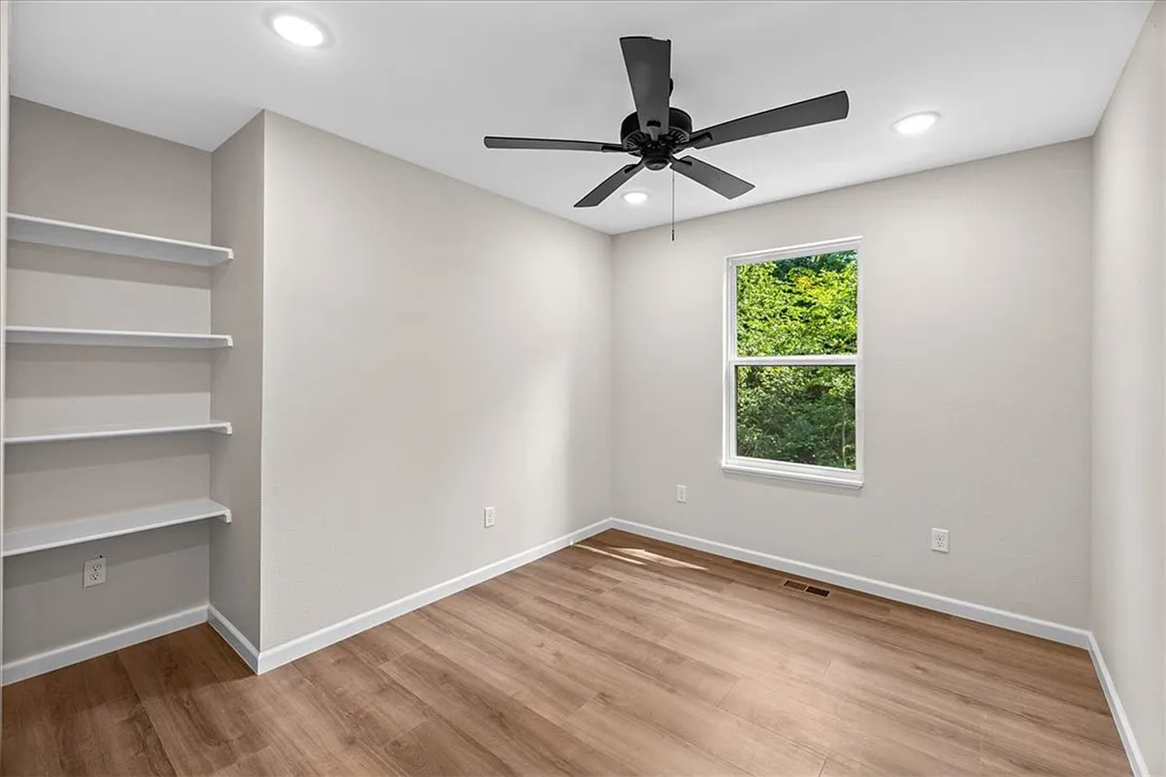 Bedroom with built-in shelving and tree view
